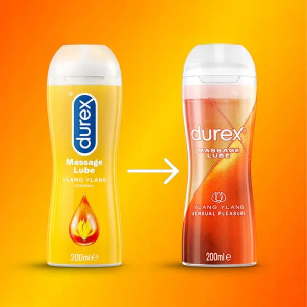 A side-by-side comparison of the 'Old Pack' and the updated bottle design for Durex Ylang Ylang Massage Lube. The old version on the left is a solid bright yellow bottle with a drop icon, while the new version on the right is translucent with a more modern, textured sunset-colored aesthetic.