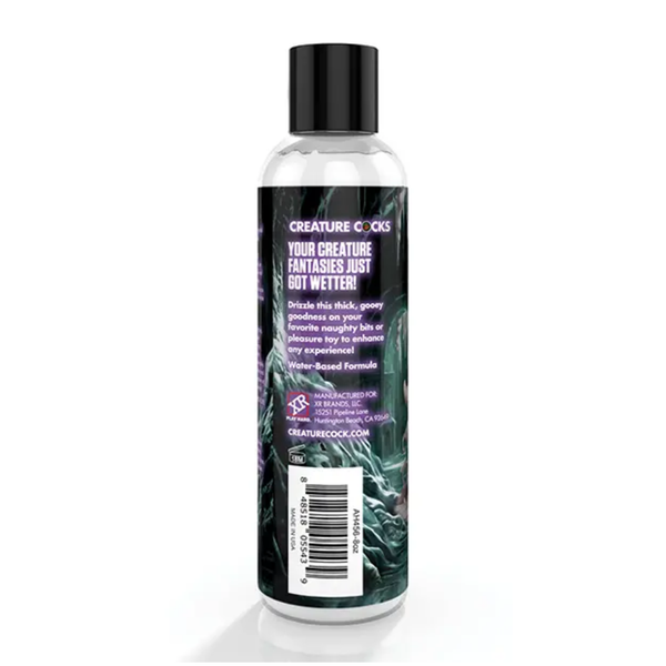 Studio view focusing on the side-back panel of the squeeze bottle, showing product description text ("Drizzle this thick, gooey goodness on your favorite naughty bits or pleasure toy"), water-based formula callout, barcode, and manufacturer info.