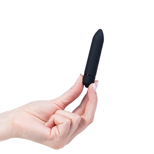 Scale reference photo showing a hand holding the matte black bullet vibrator upright by its base.