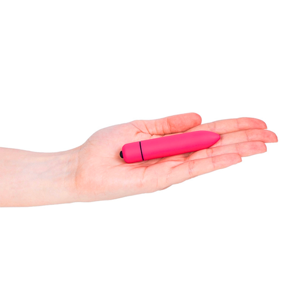 Scale perspective photo showing the small bright pink bullet vibrator lying flat in the open palm of a hand.