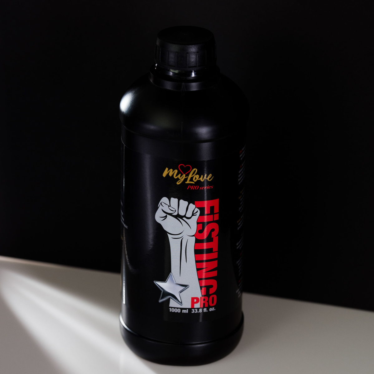 Front view of the MyLove Fisting Pro Gel 1000 ml bottle standing centered on a white surface against a solid black background.