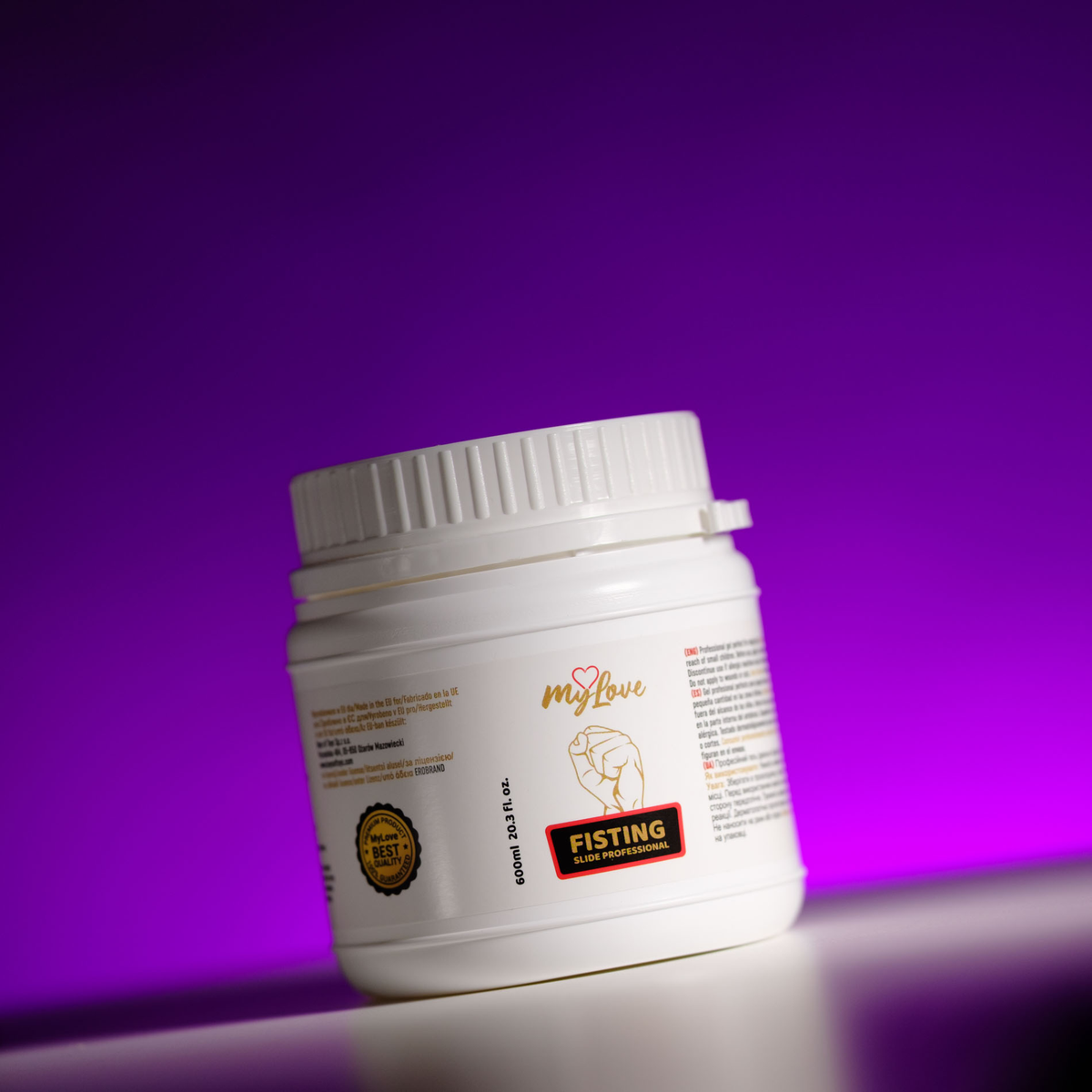 Front view of the 600 ml MyLove Fisting Slide Professional gel tub, angled slightly on a white surface against a vibrant purple backlit background.