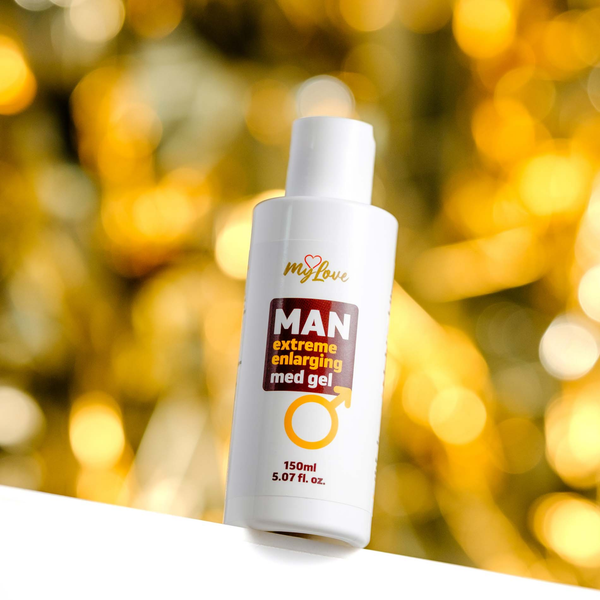 Front view of the 150 ml MyLove Man Extreme Enlarging Med Gel bottle set against a warm, heavily blurred golden bokeh lighting background.