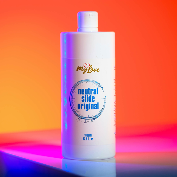 Front view of the 1000 ml MyLove Neutral Slide Original bottle standing on a reflective surface against a bold orange and pink gradient studio background.
