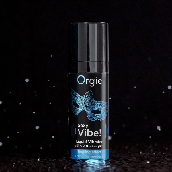 A small black pump bottle of Orgie Sexy Vibe! Liquid Vibrator Gel with blue text and a blue mask design, set against a dark, sparkling background.