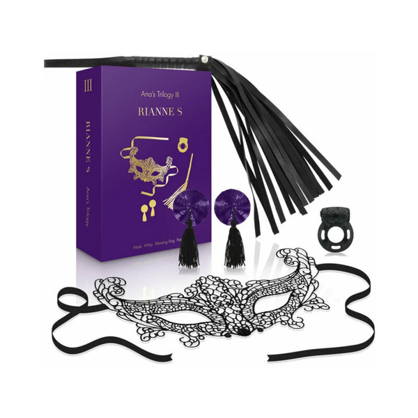 Complete product set display showing the purple gift box surrounded by all included items: black lace mask, faux-leather flogger, purple sequined pasties, and black vibrating ring.