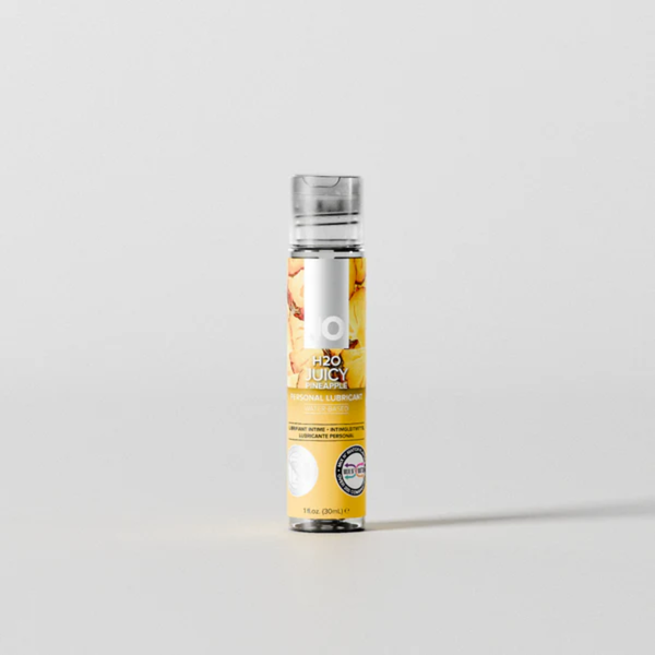Front view of the smallest 1 fl. oz. (30ml) bottle of System JO H2O Juicy Pineapple lubricant. The slim clear container features a yellow pineapple-patterned label and stands centered against a light grey background.